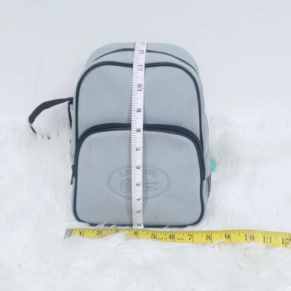 Lacoste mini backpack in a soft light blue shade with navy blue trim accents.